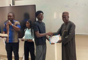 Amb. Gana (right) presenting a certificate to one of the beneficiaries