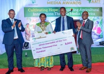 Prof Adolf Mkenda, Ministry of Education, Science, Technology, and Innovation, United Republic of Tanzania, hands a dummy cheque to Tinsae Habte Sibane, a TV journalist working for Ethiopian Broadcasting Corporation, who emerged the overall winner during OMAs 2023. Looking on is Dr. Canisius Kanangire (left), Executive Director, AATF; and Mr. Vitumbiko Chinoko (right), OFAB Project Manager at AATF.
