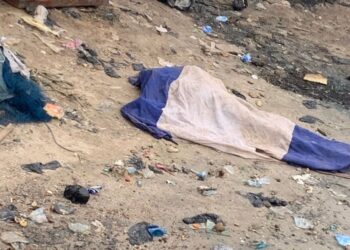 The body of the deceased covered awaiting the arrival of the police