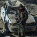 Taliban security personnel stand guard near a damaged car two days after air strikes by Pakistan in the Barmal district of eastern Paktika province on December 26, 2024. © Ahmad Sahel Arman, AFP