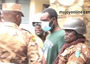 Inspector Ahmed Twumasi (in polo shirt) being guarded by Prison Officers. (PHOTO CREDIT: Myjoyonline)