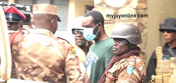 Inspector Ahmed Twumasi (in polo shirt) being guarded by Prison Officers. (PHOTO CREDIT: Myjoyonline)