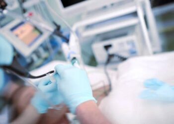 Doctor performing endoscopic procedure to the patient in the ICU.