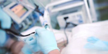 Doctor performing endoscopic procedure to the patient in the ICU.