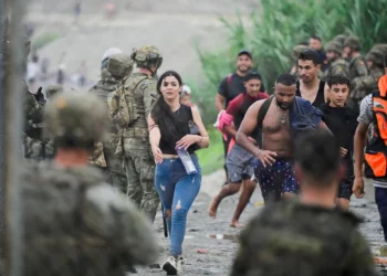 People from Morocco arrive at the Spanish border in Ceuta on 31 July 2026, as thousands enter the enclave by land and sea (Reuters)
